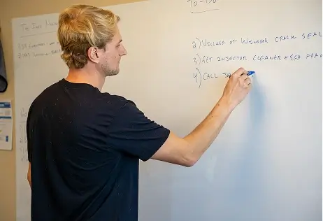 Man writing onto whiteboard